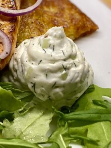 Frischkäse mit Gurke und Dill, cremig und frisch, auf Salat serviert.