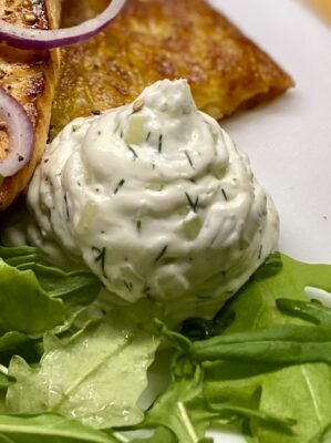 Frischkäse mit Gurke und Dill, cremig und frisch, auf Salat serviert.