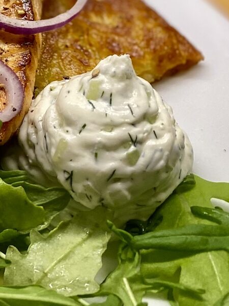 Frischkäse mit Gurke und Dill, cremig und frisch, auf Salat serviert.